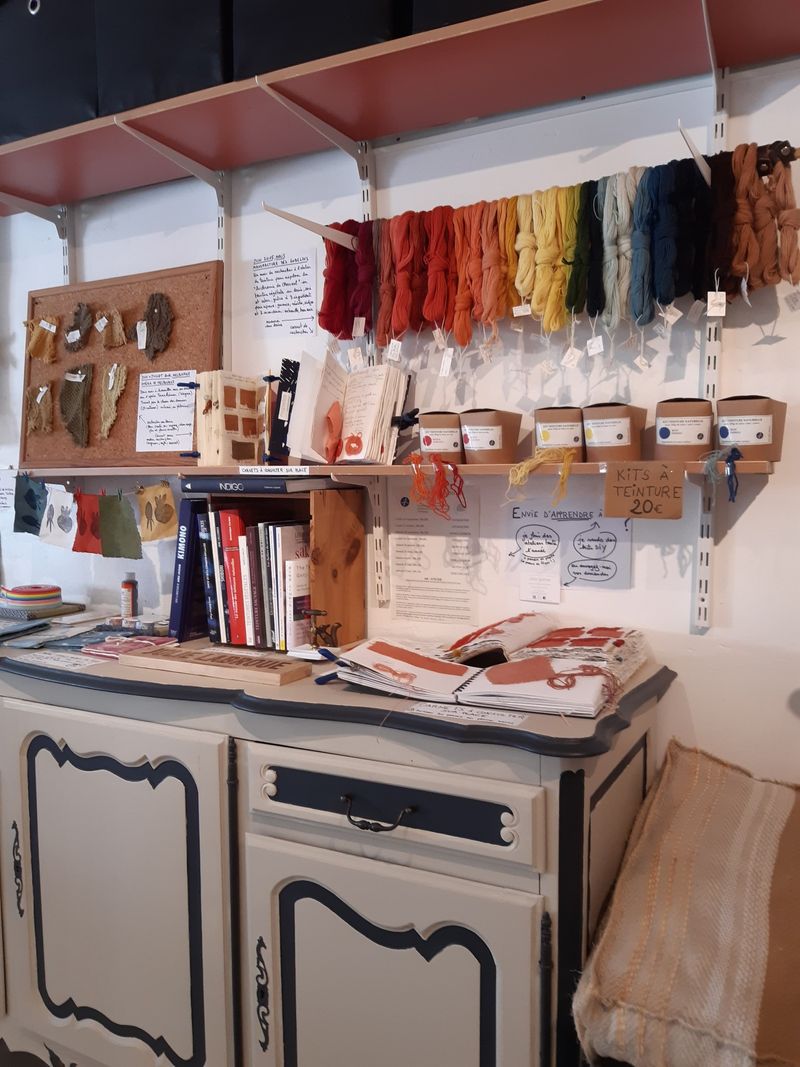 Étagère remplie de pelottes de laines de différentes couleurs